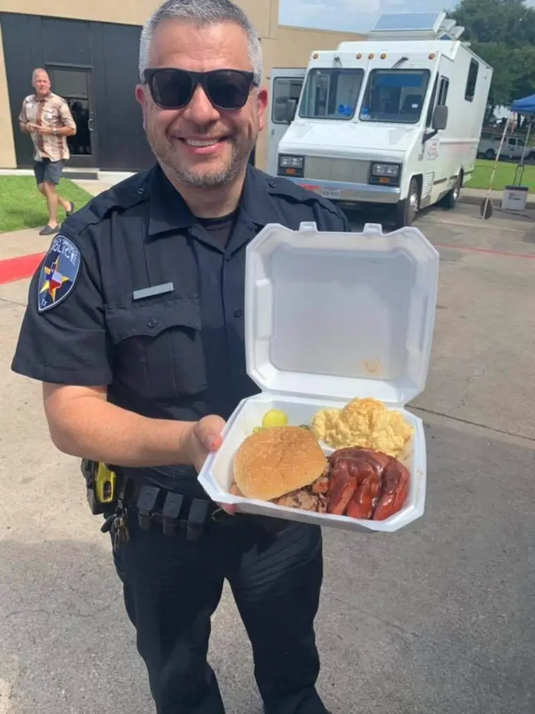 Police officer holding a free barbecue plate
